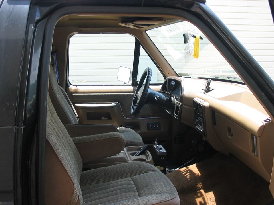 1988 Ford Bronco interior showing front seats, dashboard, steering wheel, and center console