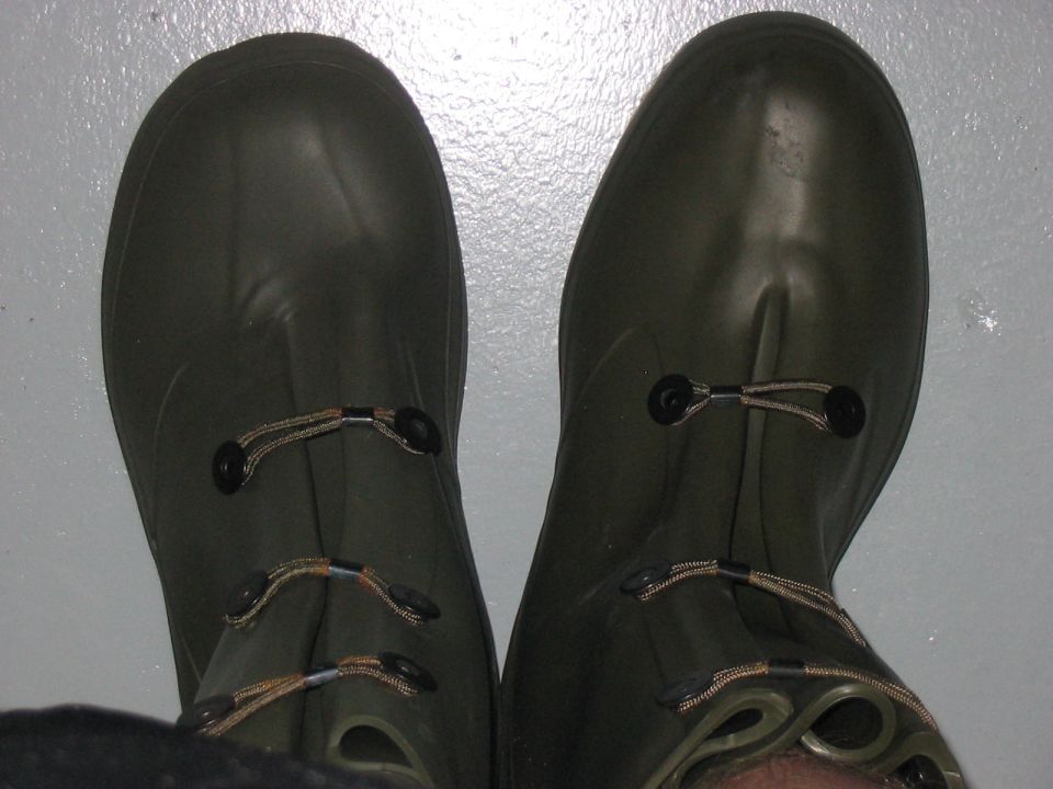 pair of green rubber boots with elastic laces