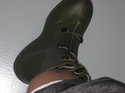 1988 Ford Bronco - A green rubber boot is shown from a high angle, with a portion of a leg visible.