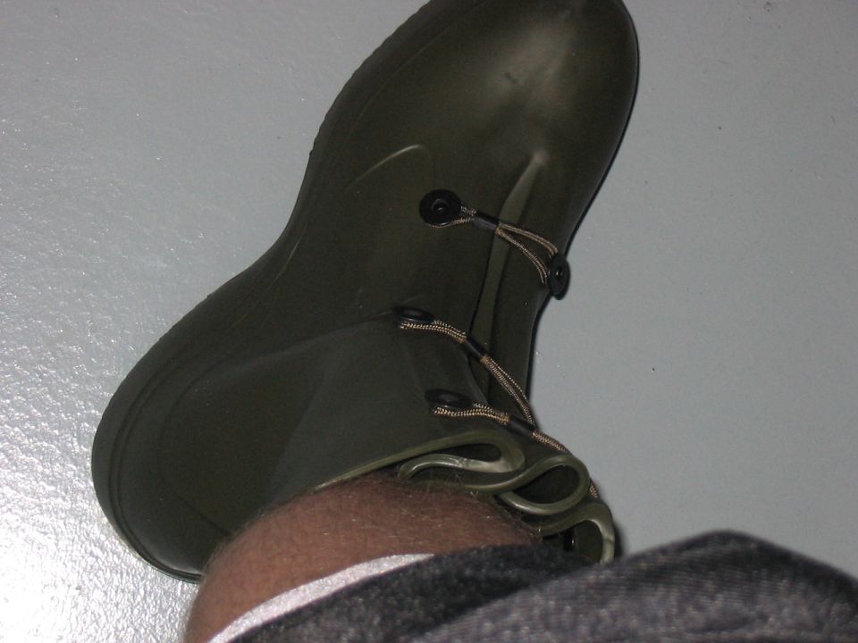 Green rubber boot with laces and toggles, seen from above