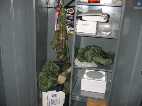 1988 Ford Bronco - Contents of a military locker include camouflage apparel, green duffel bags, and various boxes on shelves.