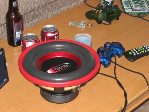 1988 Ford Bronco - A Visonik subwoofer sits on a table next to soda cans, a beer, a candle, and gaming controllers.