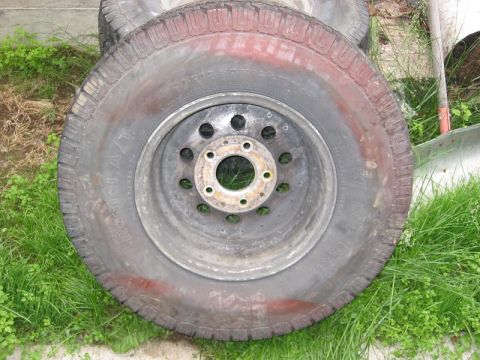 1985 Ford Bronco - A single tire and rim assembly is shown, with some red paint markings on the tire's sidewall.