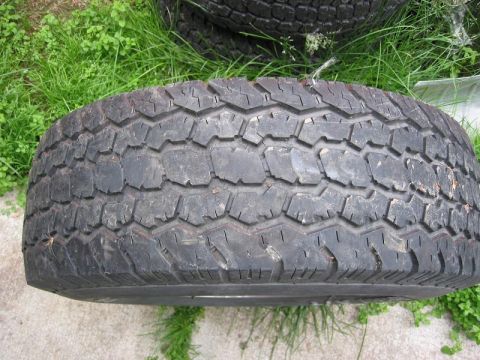 1985 Ford Bronco - A single tire is shown, likely for an off-road vehicle, with a prominent tread pattern.