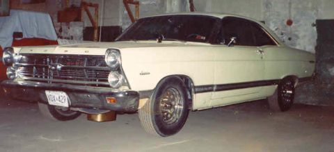 1967 Ford Fairlane - A 1967 Ford Fairlane coupe is shown from the front three-quarter angle in an indoor setting.
