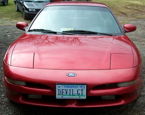 1996 Ford Probe - Front view of a red 1996 Ford Probe, parked outdoors with another vehicle in the background.