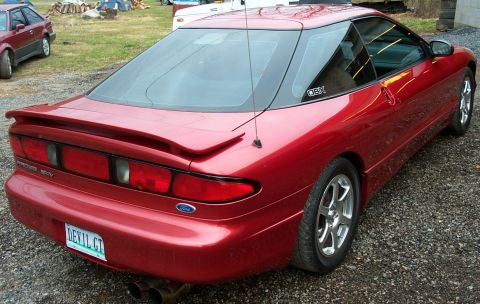1996 Ford Probe - A red 1996 Ford Probe is viewed from the rear, showing its spoiler and custom license plate.