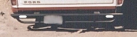 1978 Ford Bronco - The rear of a white pickup truck is visible, showing the tailgate and bumper.