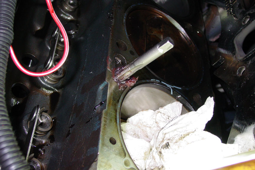 Engine block with valve springs exposed and a broken tap stuck in a bolt hole