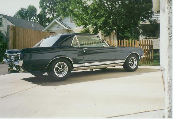 Dark 1967 Ford Mustang coupe parked on a driveway