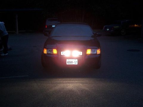 2001 Ford Crown Victoria - Front view of a 2001 Ford Crown Victoria at night, with bright auxiliary lights illuminating the scene.