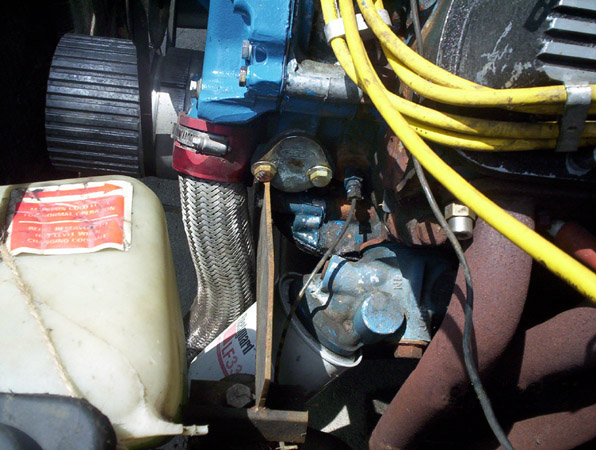 Engine bay with coolant reservoir, braided hose, and yellow spark plug wires