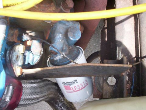 1978 Ford Mustang II - Close-up of an oil filter and associated engine parts, showing a yellow hose and exhaust system.