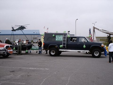 1996 Ford Bronco - Truck towing a trailer with a helicopter and boat, decorated with green balloons.