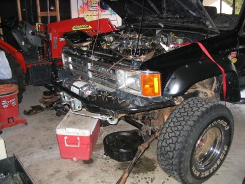 1986 Ford F-150 - This Toyota Land Cruiser is undergoing maintenance in a garage, with its engine compartment open.