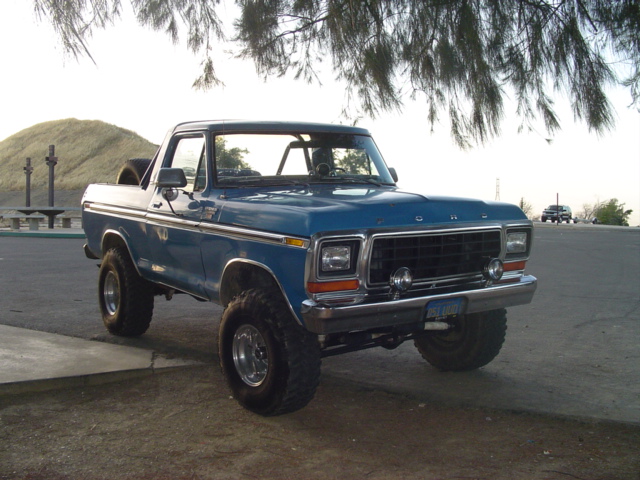 1978 Ford Bronco parked on asphalt, 3/4 front view, with off-road tires and a spare tire visible