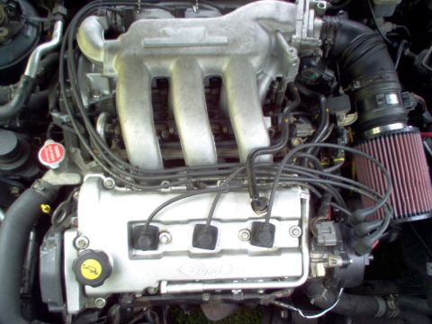 1996 Ford Probe - Close-up view of a Ford engine, showing the intake manifold, spark plug wires, and air filter.