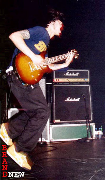2000 Jeep Liberty - A musician performs on stage, jumping while playing a sunburst electric guitar with Marshall amplifiers behind him.