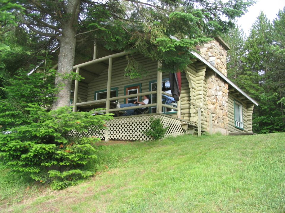 Log cabin with a person relaxing on the porch