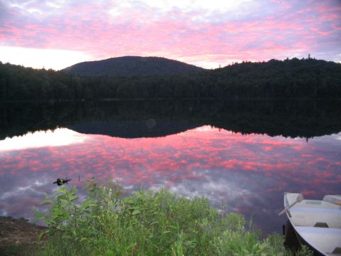 1986 Ford Bronco - Sunset over a lake with reflections of colorful clouds and forested hills.