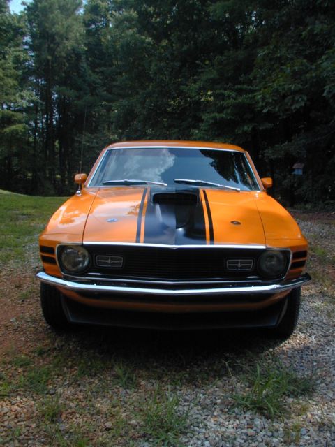 1988 Ford Bronco - Front view of an orange 1969 Ford Mustang with black racing stripes on the hood.