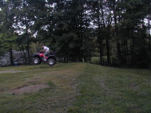 1988 Ford Bronco - ATV rider catches air while going over a hill in a grassy area.