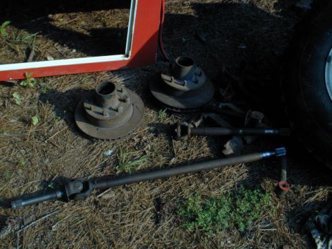 1988 Ford Bronco - Various axle components, including brake rotors and driveshafts, are laid out on the ground.