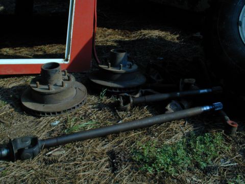 1988 Ford Bronco - Axle shafts and brake components are laid out on the ground.