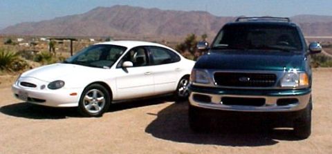 1997 Ford Expedition - A 1997 Ford Expedition is parked in front of a white sedan with mountains in the background.
