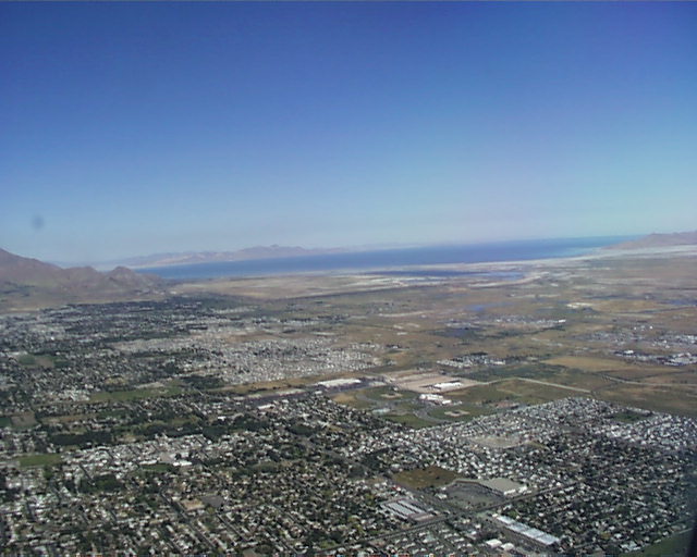 Aerial view of a valley town with a large lake and mountains in the distance