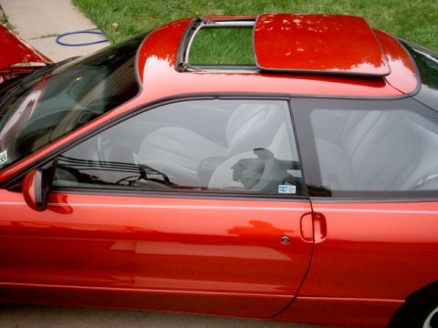 1996 Ford Probe - Side view of a red 1996 Ford Probe coupe, showing its sunroof and interior details.