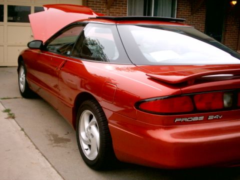 1996 Ford Probe - Red 1996 Ford Probe 24V coupe shown from the rear quarter angle with the hood open.