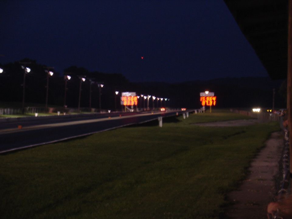 Drag strip at night with illuminated scoreboards and lights
