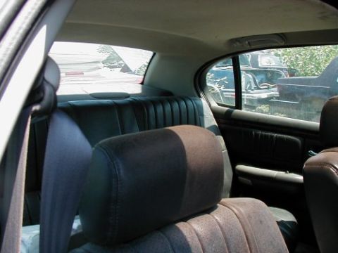 1997 Ford Taurus - View from inside a car shows the rear seats and a glimpse of other vehicles in an outdoor storage area.
