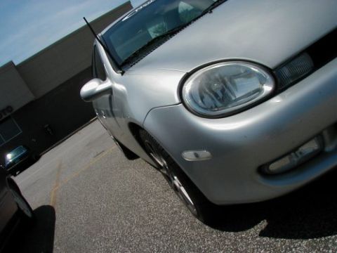 1997 Ford Taurus - A silver Dodge Neon is parked in a lot with another vehicle visible in the background.