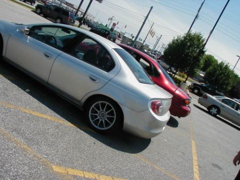 1997 Ford Taurus - Silver sedan and red sedan parked in a lot on a sunny day.