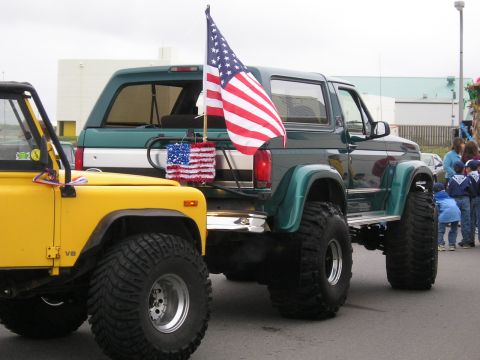 1996 Ford Bronco - Green 1996 Ford Bronco decorated with an American flag for a parade or event.