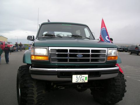 1996 Ford Bronco - A modified 1996 Ford Bronco is shown from the front, oversized tires and a decorative flag.