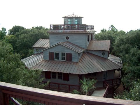 1998 Ford Taurus - A multi-level house with a lighthouse-like observation deck is among lush green trees.