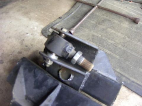 1980 Ford Bronco - Suspension part and lug wrench on a floor, likely in a garage or workshop.