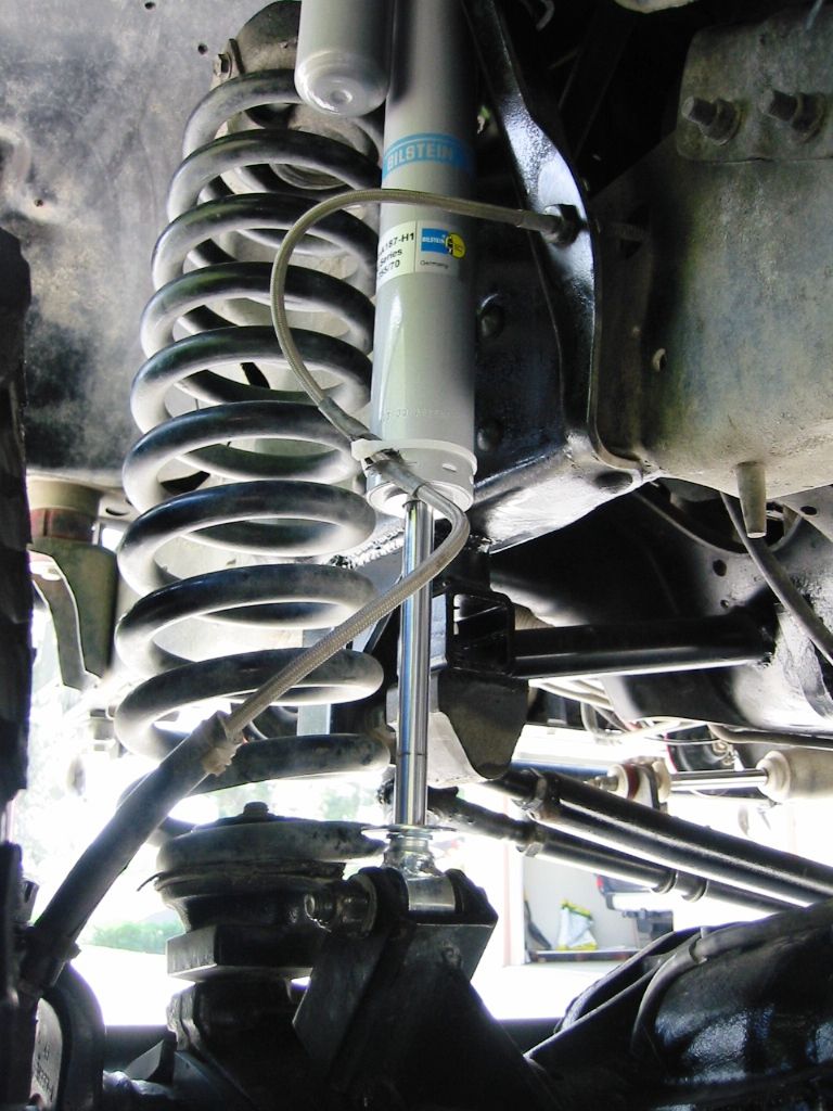 Underside view of coil spring and Bilstein shock in vehicle front suspension
