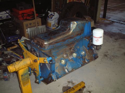 1967 Ford Galaxie - A blue engine block with a Motorcraft oil filter attached sits on a yellow engine stand.