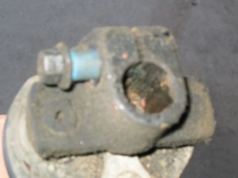 1989 Ford Bronco - Extreme close-up of a heavily grease-caked pinch-bolt yoke end of a steering shaft coupler, showing the splined bore and the pinch bolt wit…