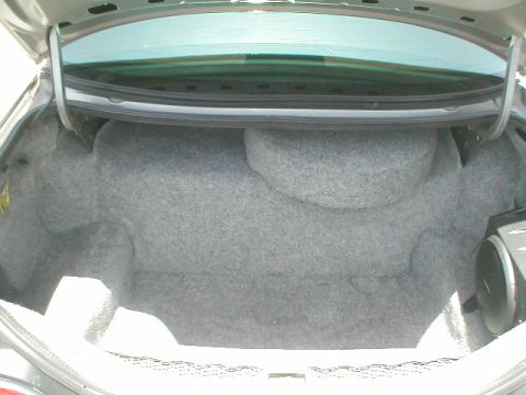 1994 Ford Crown Victoria - The trunk of a car, showing the spare tire compartment and carpet.