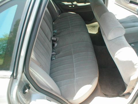1994 Ford Crown Victoria - The interior of a car shows the rear bench seat and a portion of the front passenger seat.