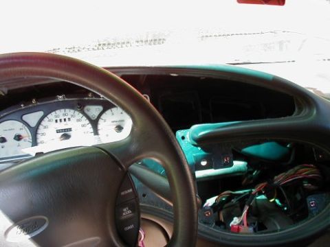 1997 Ford Taurus - Interior view of a 1997 Ford Taurus dashboard, with the instrument cluster and radio disassembled to reveal wiring.