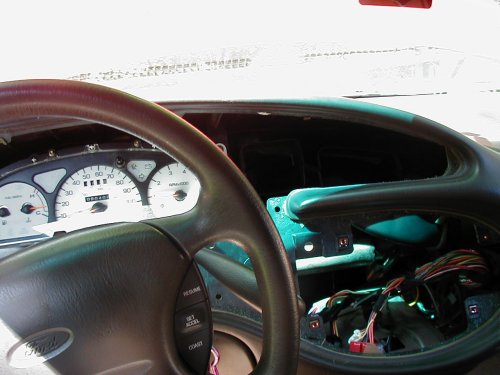 Dashboard of a 1997 Ford Taurus with the instrument cluster and radio removed, showing wiring