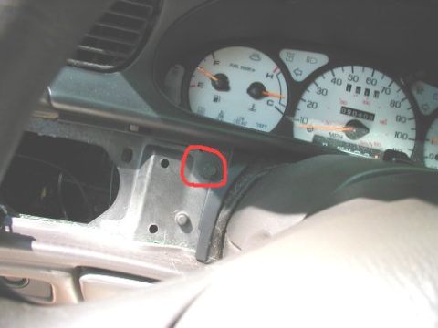 1997 Ford Taurus - Close-up of a car's instrument cluster, highlighting a screw with a red circle on the dashboard.