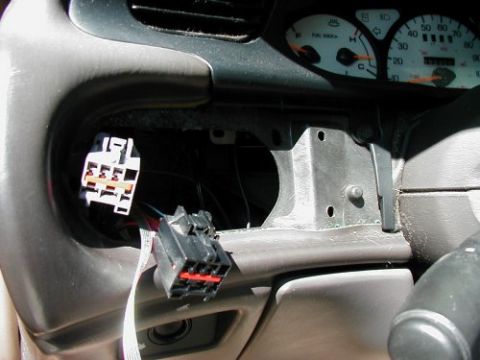 1997 Ford Taurus - Wiring harnesses are exposed after removing the radio and instrument cluster from the vehicle's dashboard.