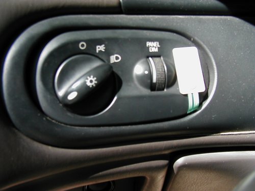 Headlight switch with symbols for off, parking lights, and headlights; and a panel dimmer knob